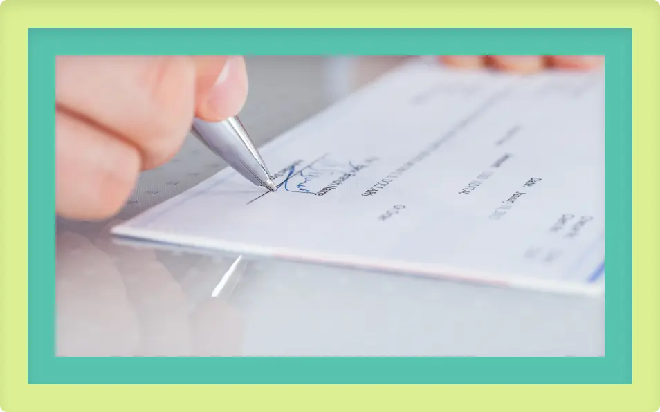 A person writing on a check