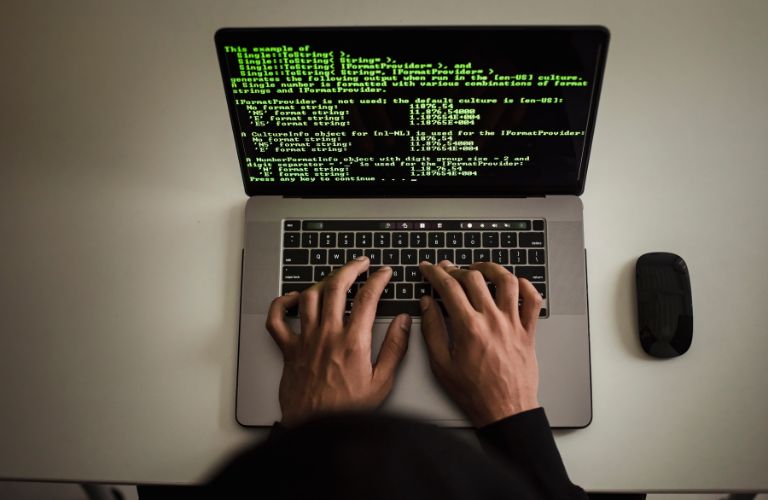 Overhead View of Person Working on Code on a Laptop