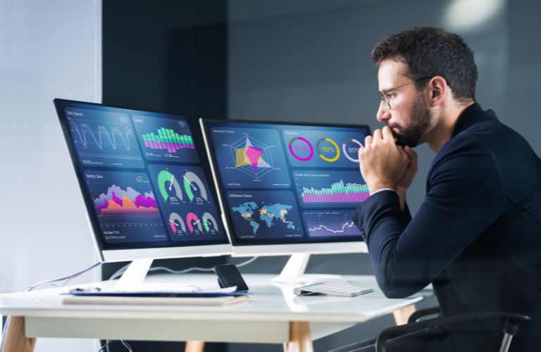 Man Looking at Data on Computers