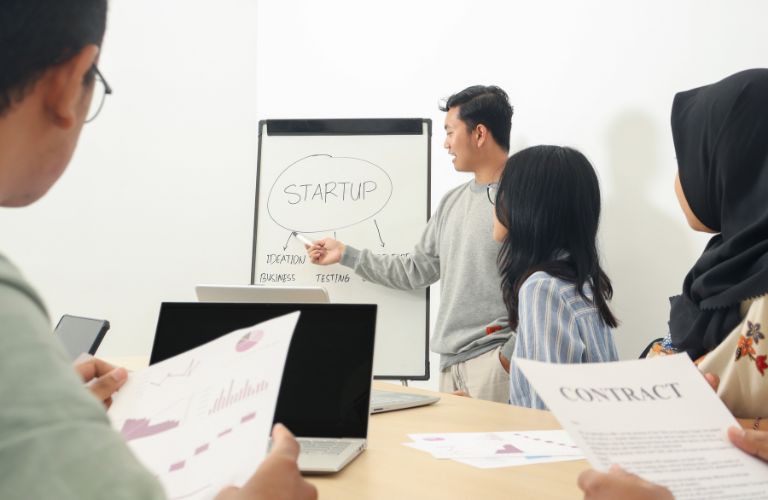 People with White Board Having a Meeting About a Startup