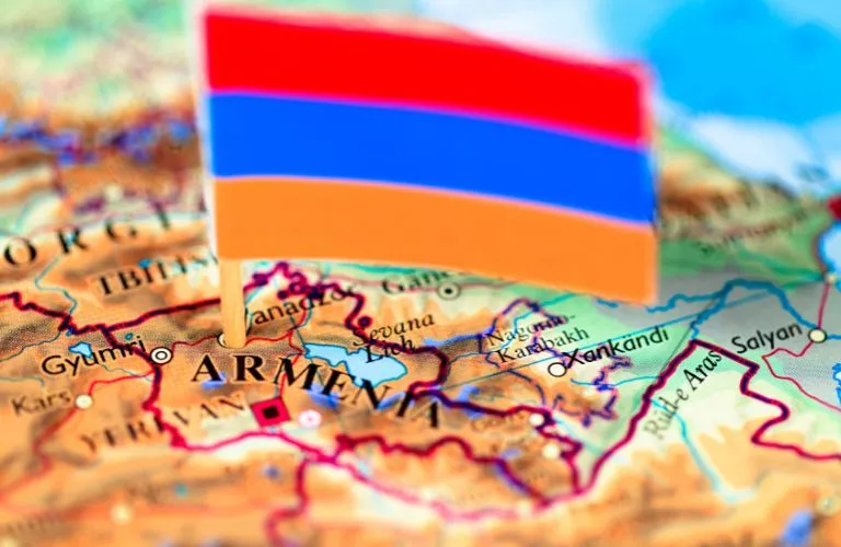 Small Armenian flag placed on a detailed map highlighting Armenia and surrounding regions.