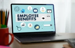 Laptop displaying "Employee Benefits" text with various business-related icons on screen.