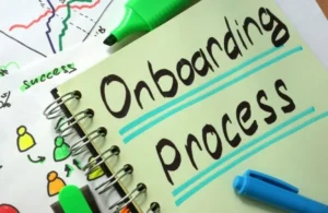 Notebook page with "Onboarding Process" handwritten in black, highlighted with blue lines, alongside colorful markers and a diagram.