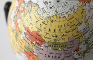 Close-up view of a colorful globe focusing on Russia, Mongolia, China, and surrounding regions with labeled cities and seas.