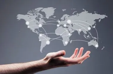 Human hand beneath a digital world map with interconnected glowing network nodes.
